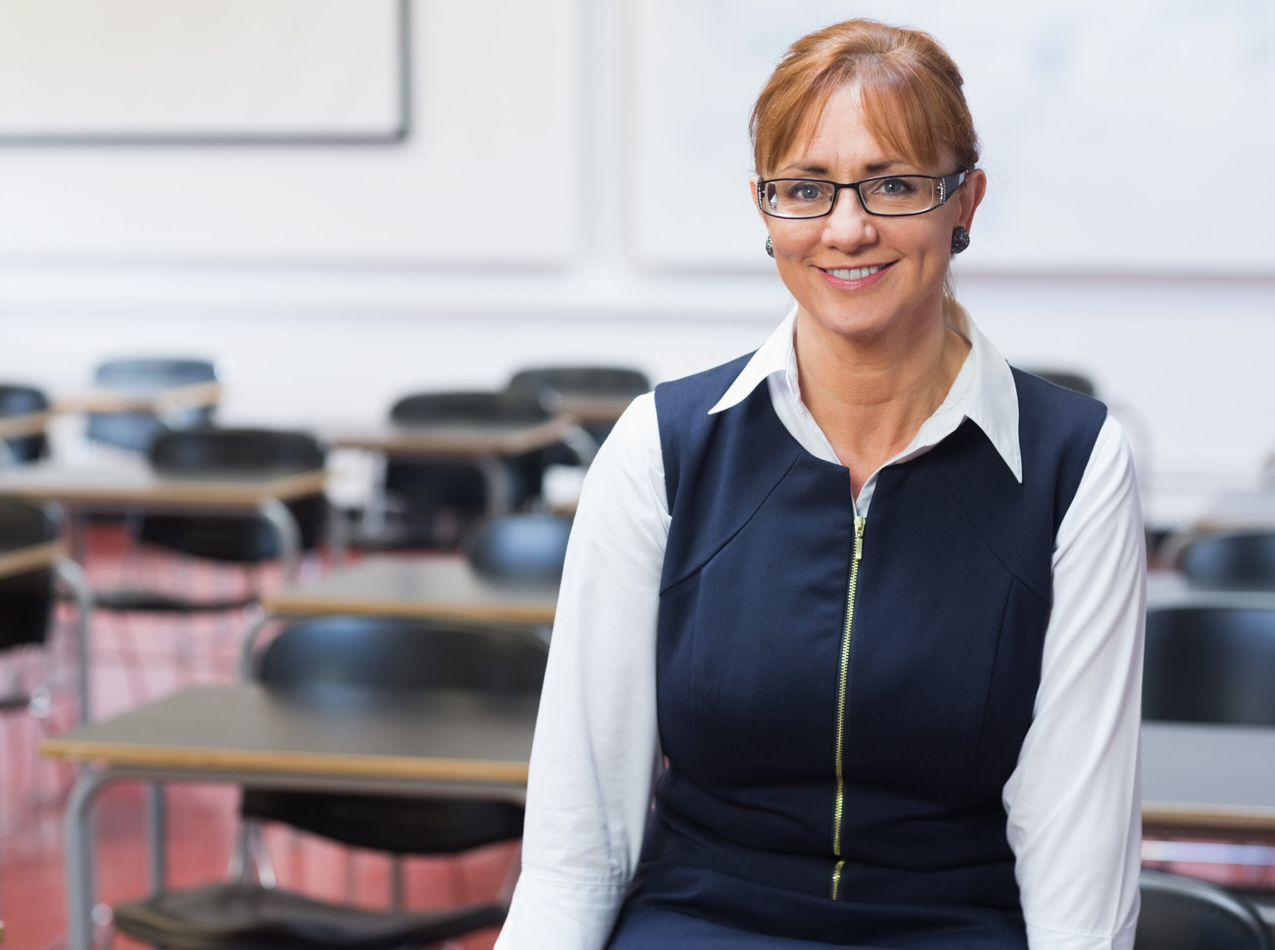 Portrait,Of,A,Smiling,Female,Teacher,In,The,Class,Room