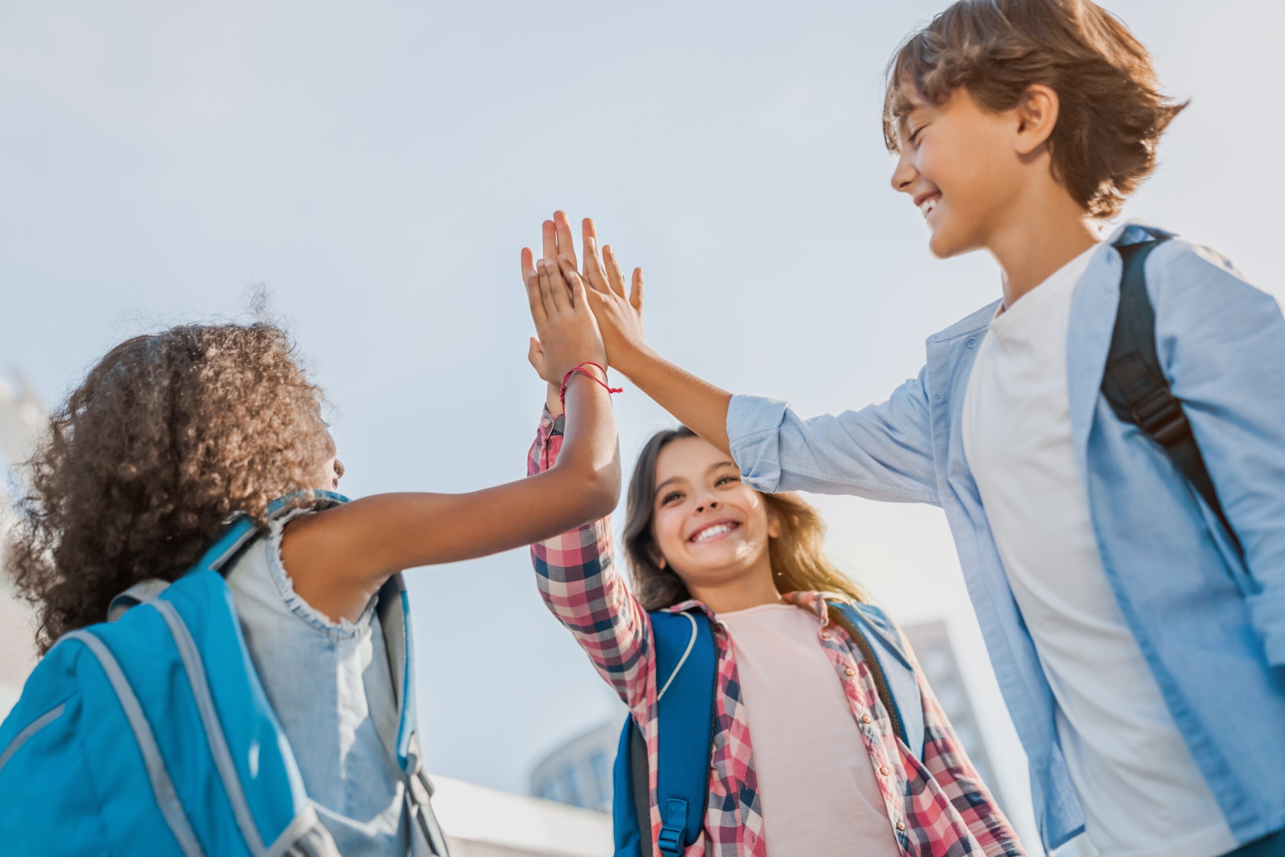 Happy,Children,Giving,High,Five,Each,Other,Standing,Near,School