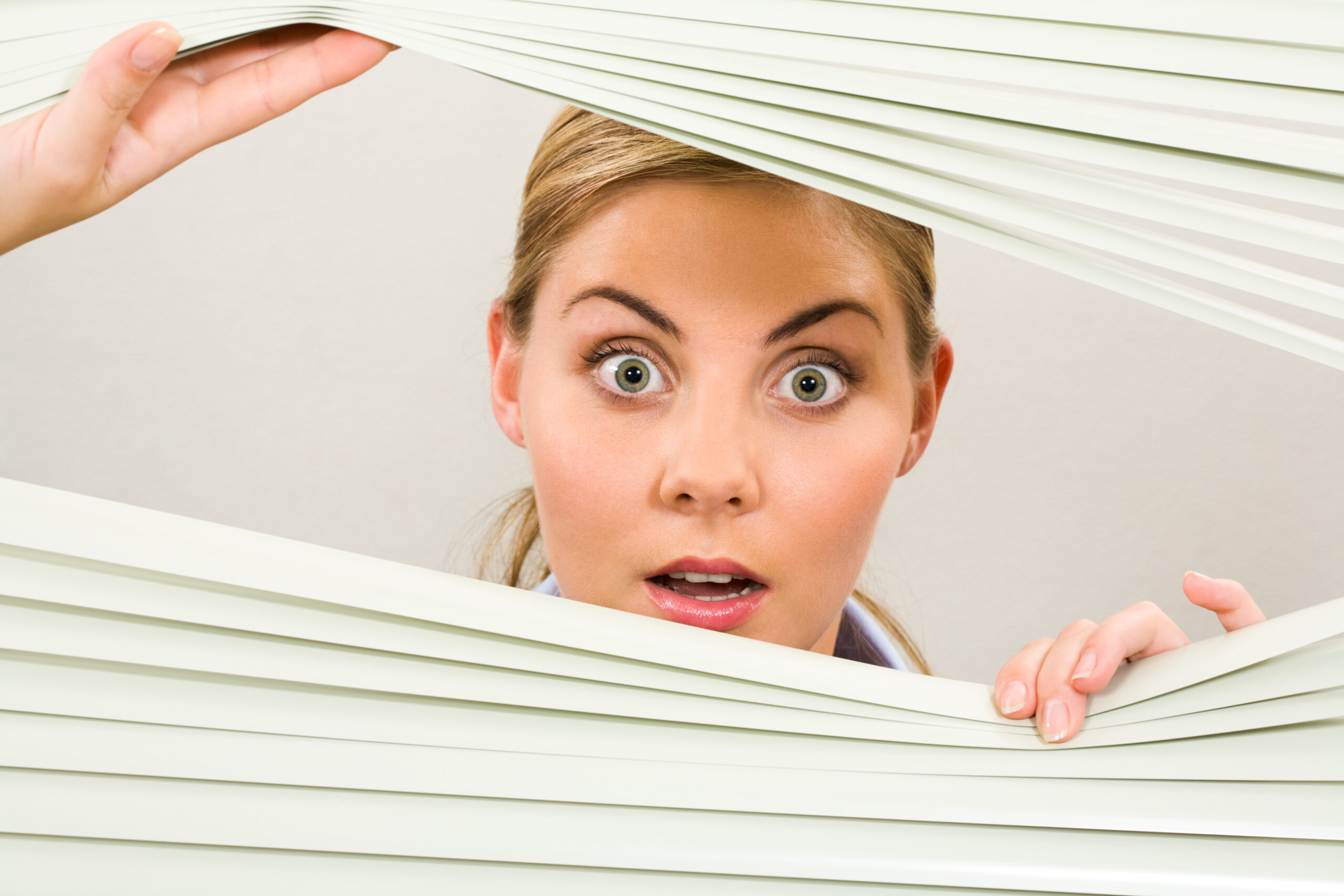 Portrait,Of,Surprised,Woman,Looking,At,Camera,Out,Of,Venetian