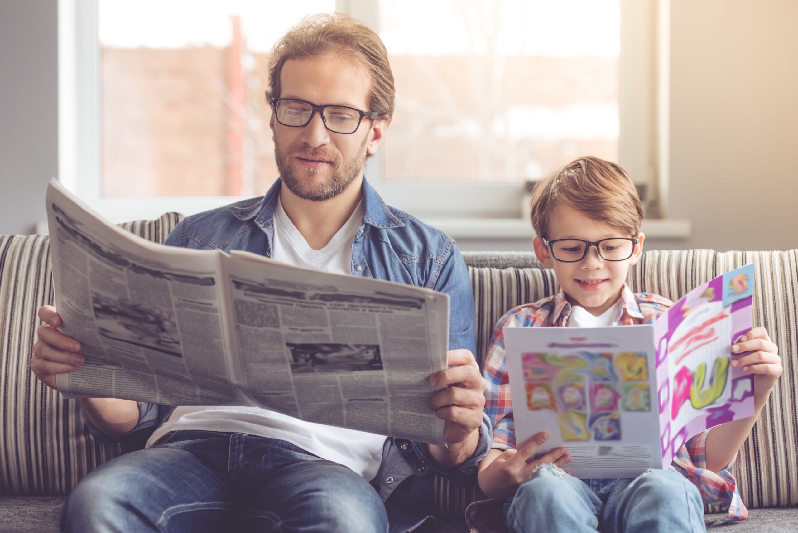 Father,And,Son,Are,Reading,Newspapers,And,Smiling,While,Spending