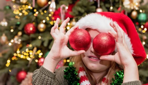 Holiday,Joy,Child,Wearing,Santa,Hat,And,Holiday,Scarf,Holding