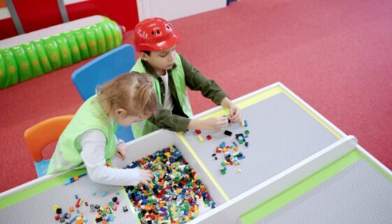 Joyful,Children,Wearing,Waistcoats,Building,With,Colorful,Blocks,Together,In